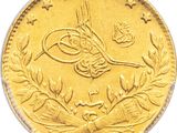 Gros plan sur une pièce d'or portant une écriture arabe