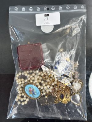 un sac contenant des bijoux posé sur une table à côté d'une tasse de café