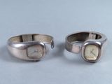 une paire de bagues en argent, avec une montre de chaque côté