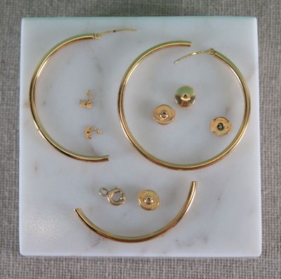 gold hoop earrings and earring set on a marble slab