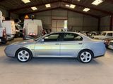 a silver car parked in a garage with other cars in the background