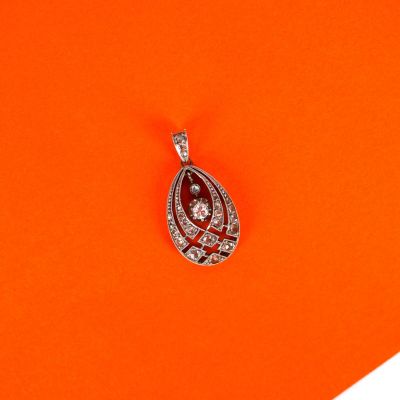 a close up of a diamond pendant on an orange background
