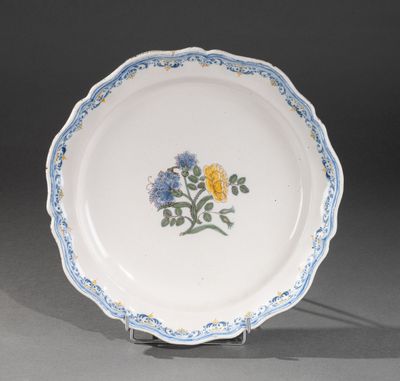 un gros plan d'une assiette blanche ornée de fleurs bleues et jaunes
