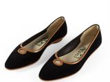 une paire de chaussures en daim noir avec des bordures marron sur fond blanc