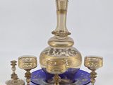 brass and blue glass decanter set with four cups and a decanter