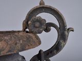 a large metal bowl with a handle on a table