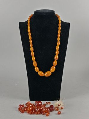 an orange beaded necklace and bracelet set on a mannequin