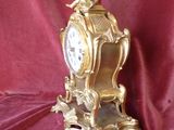 a gold clock sitting on top of a red cloth
