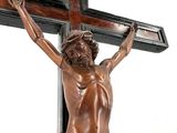 une statue en bronze représentant Jésus sur une croix, posée sur une table