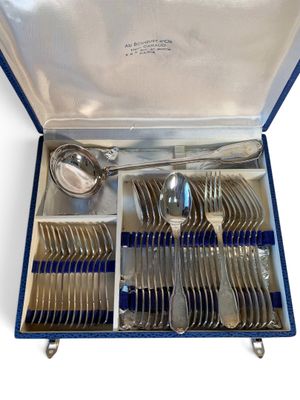 un service d'argenterie dans un coffret bleu posé sur une surface blanche