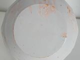 a white plate with rust on it sitting on a table