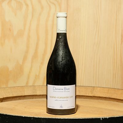 une bouteille de vin posée sur un tonneau