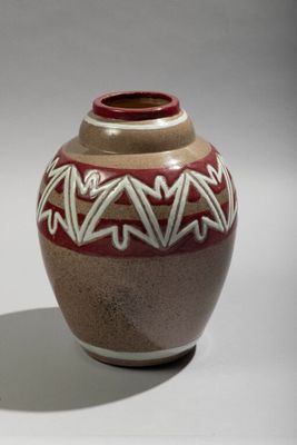 a brown vase with a red and white design on it