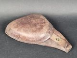 un chapeau en cuir marron posé sur une surface noire
