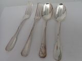 four silver spoons and a fork on a white surface