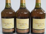 three bottles of wine are lined up on a white surface