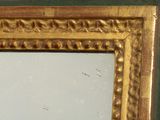 a mirror with a gold frame on the wall