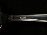 a silver spoon with a silver handle on a black surface