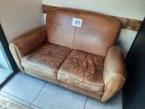 a brown leather couch with a price tag on it