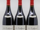 trois bouteilles de vin rouge posées sur une table