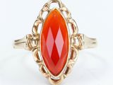 an image of a gold ring with an orange stone in it