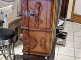 a tall wooden chest sitting on top of a stool