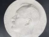 a close up of a silver medal with a man ' s face on it