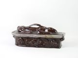 a small brown box with a statue on top of it