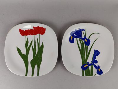 deux assiettes avec des fleurs peintes dessus, posées sur une table