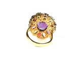 an image of a gold ring with a purple stone in the center