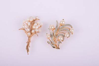 a pair of pearl and gold brooches on a white background
