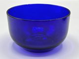 a blue glass bowl sitting on a white surface