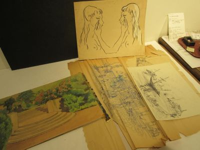 a lot of drawings on a table with a picture on it