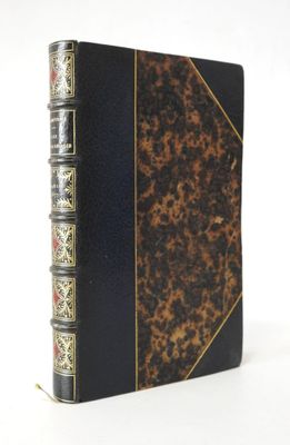un vieux livre à la couverture noire et aux bords dorés