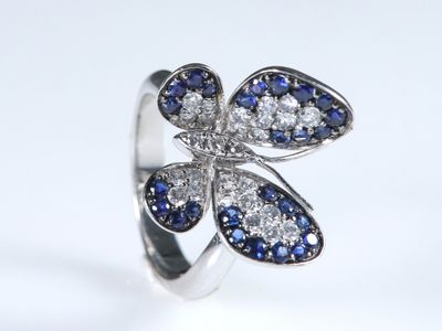 un gros plan d'une bague sertie de diamants bleus et blancs