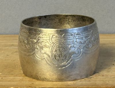 un bol en argent posé sur une table en bois, sur fond gris