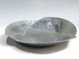 a large metal bowl with a curved edge on a white surface