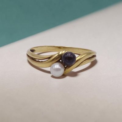 un gros plan d'une bague ornée de deux perles