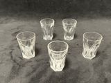 quatre verres à shot posés les uns à côté des autres sur une table