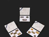 trois boîtes contenant différents types de maquillage sur une surface noire