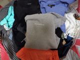 a pile of clothes in a suitcase on a bed