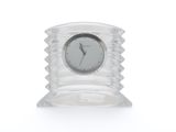 une horloge transparente posée sur une table transparente