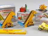 cinq camions miniatures différents et une boîte de jeux de construction