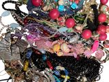 une pile de bijoux assortis sur une surface blanche