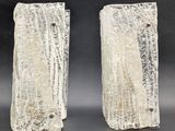 pair of white ceramic sculptures of trees on a black background