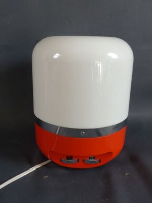 une enceinte blanche et orange posée sur une surface noire