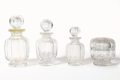 trois bouteilles en verre transparent sont alignées sur une surface blanche