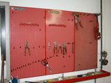 a red pegboard with scissors and other tools on it