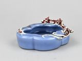 a small blue bowl with a red and white decoration on it