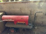 a red fire extinguisor sitting in the corner of a building